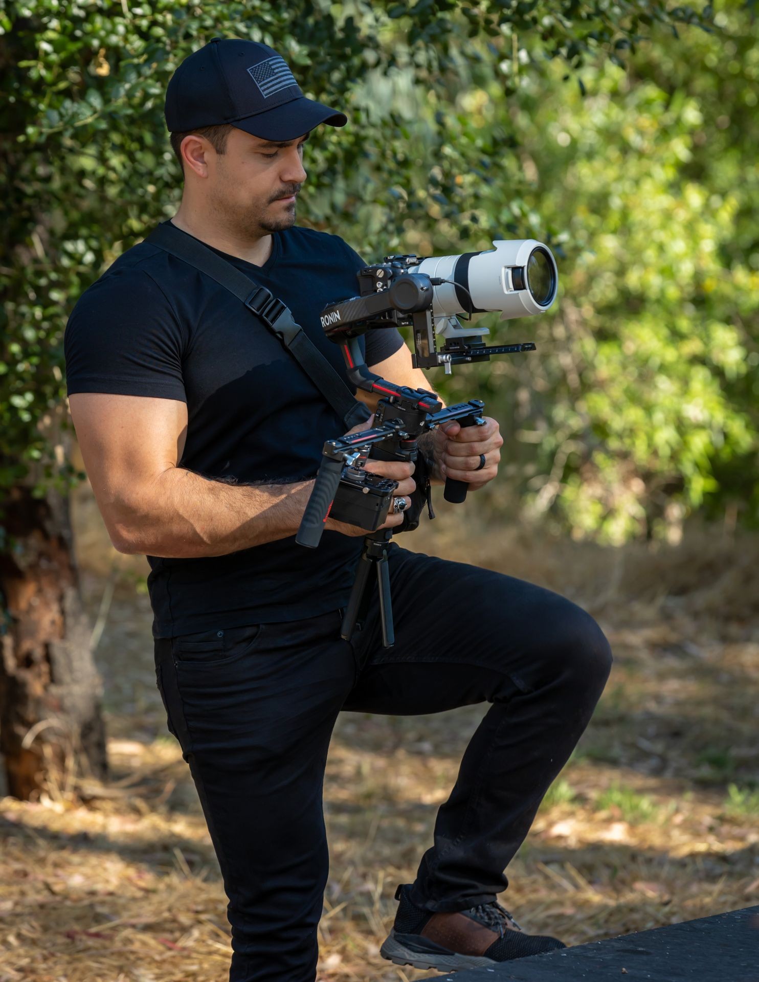 male wearing all black clothes operating gimbal and camera